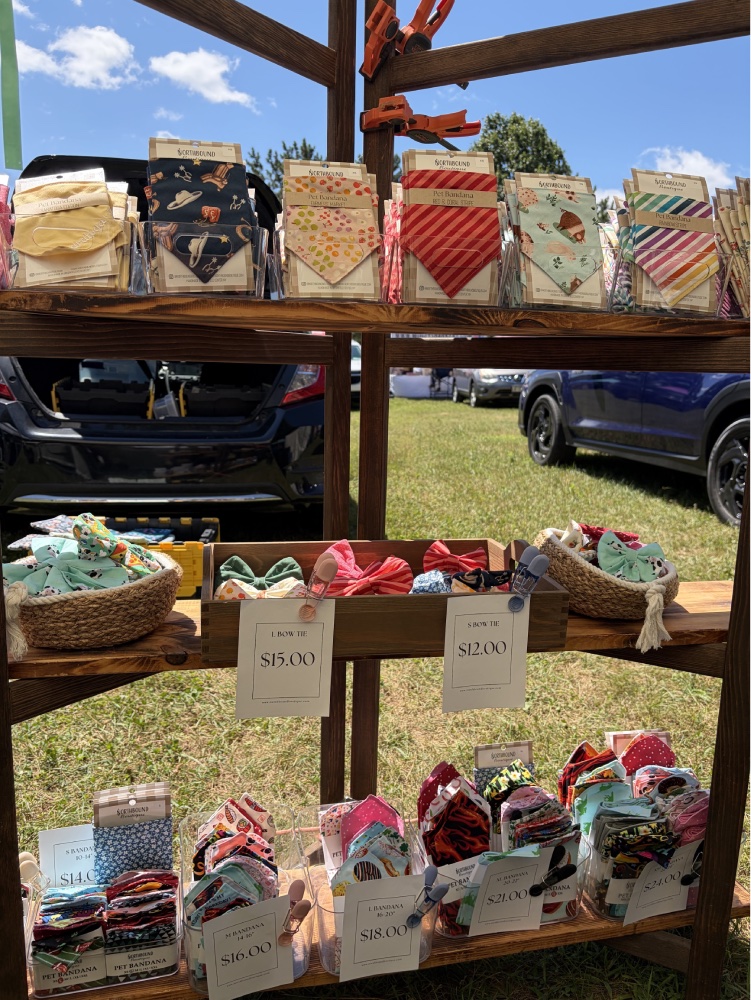 Northbound Boutique wooden display shelf featuring colorful pet bandanas and bow ties
