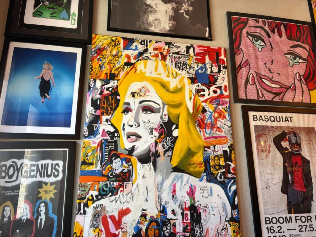 A wall of colorful framed pop-art and portraits inside Whitman Brewing.